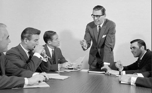 Vintage man giving presentation in office meeting.